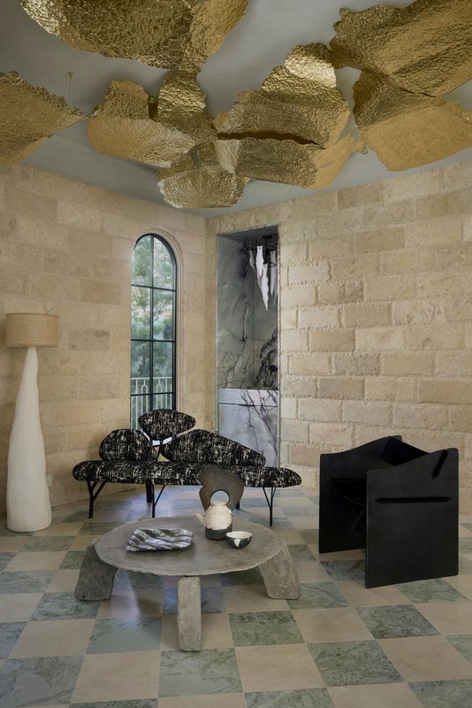 Living room with a gilded ceiling sculpture and checkerboard marble floor